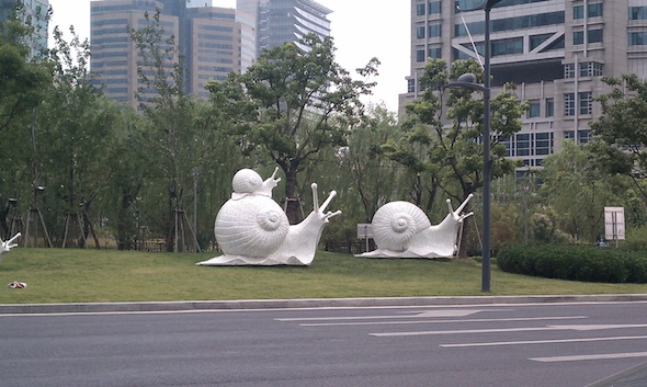 A couple of snail statues along the highway toward the Oriental Pearl Tower and other iconic buildings - PHOTOS: A Sweltering Summer Stay in China - Frayed Passport