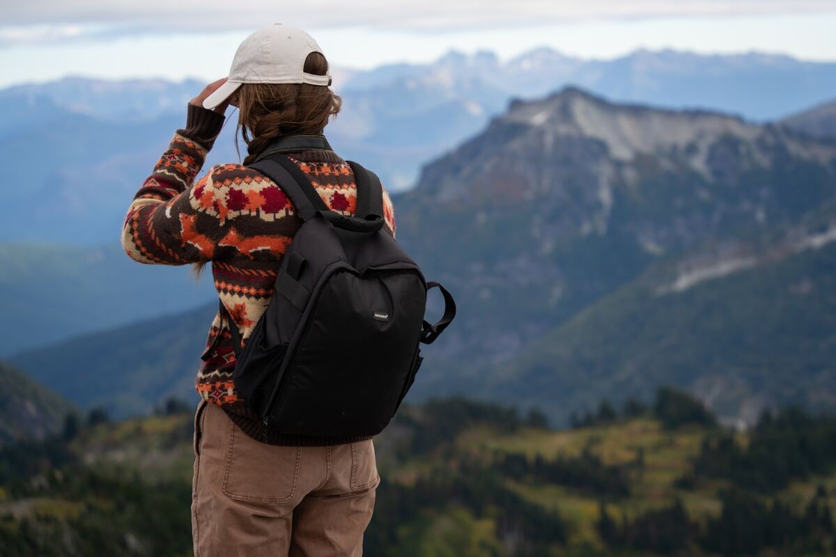 A man standing on top of a mountain with a backpack