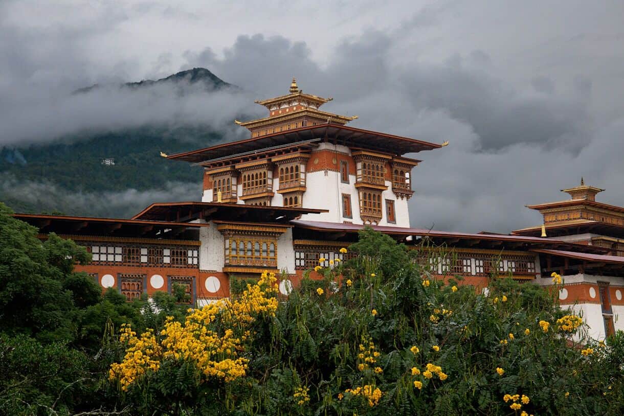 Calming Locations That Prove A Trip To Asia Doesn't Have To Be Hectic - Frayed Passport - Bhutan - A building with a mountain in the background