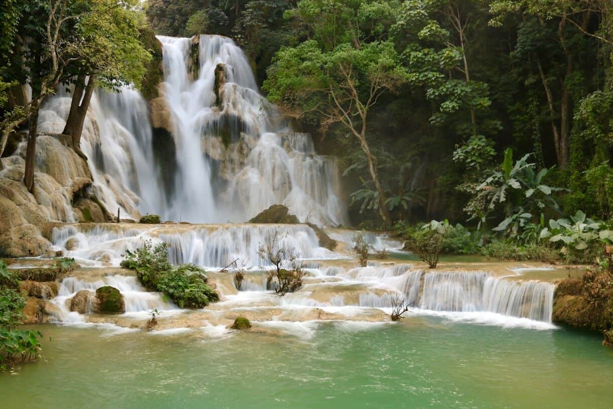 Calming Locations That Prove A Trip To Asia Doesn't Have To Be Hectic - Luang Prabang, Laos - Frayed Passport - a large waterfall in the middle of a forest