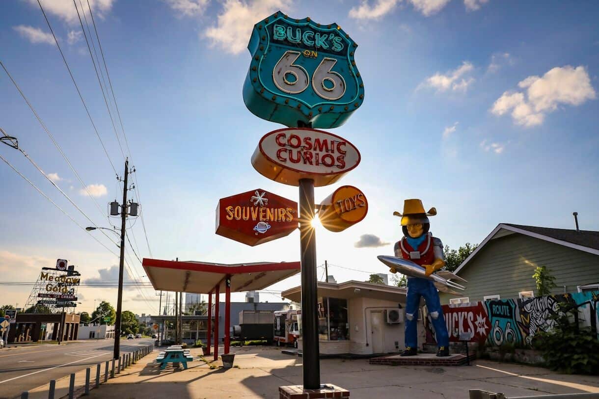 8 U.S. Cities Where $3,000 a Month Goes Further Than You'd Think - Frayed Passport - Tulsa, OK - a statue of a cowboy holding a surfboard in front of a gas station