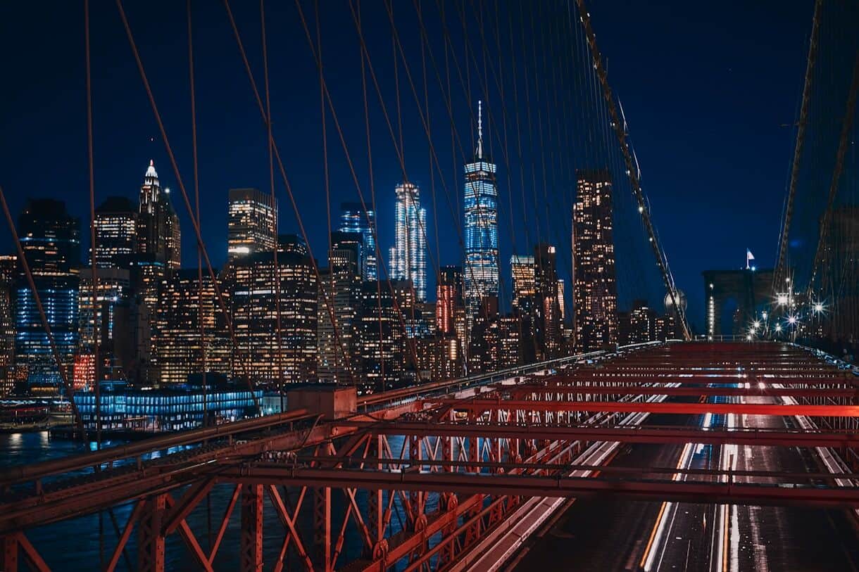bridge near city buildings during nighttime